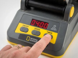 Operating the digital timer and speed settings on a National Geographic professional series rock tumbler for precise control over tumbling stages.